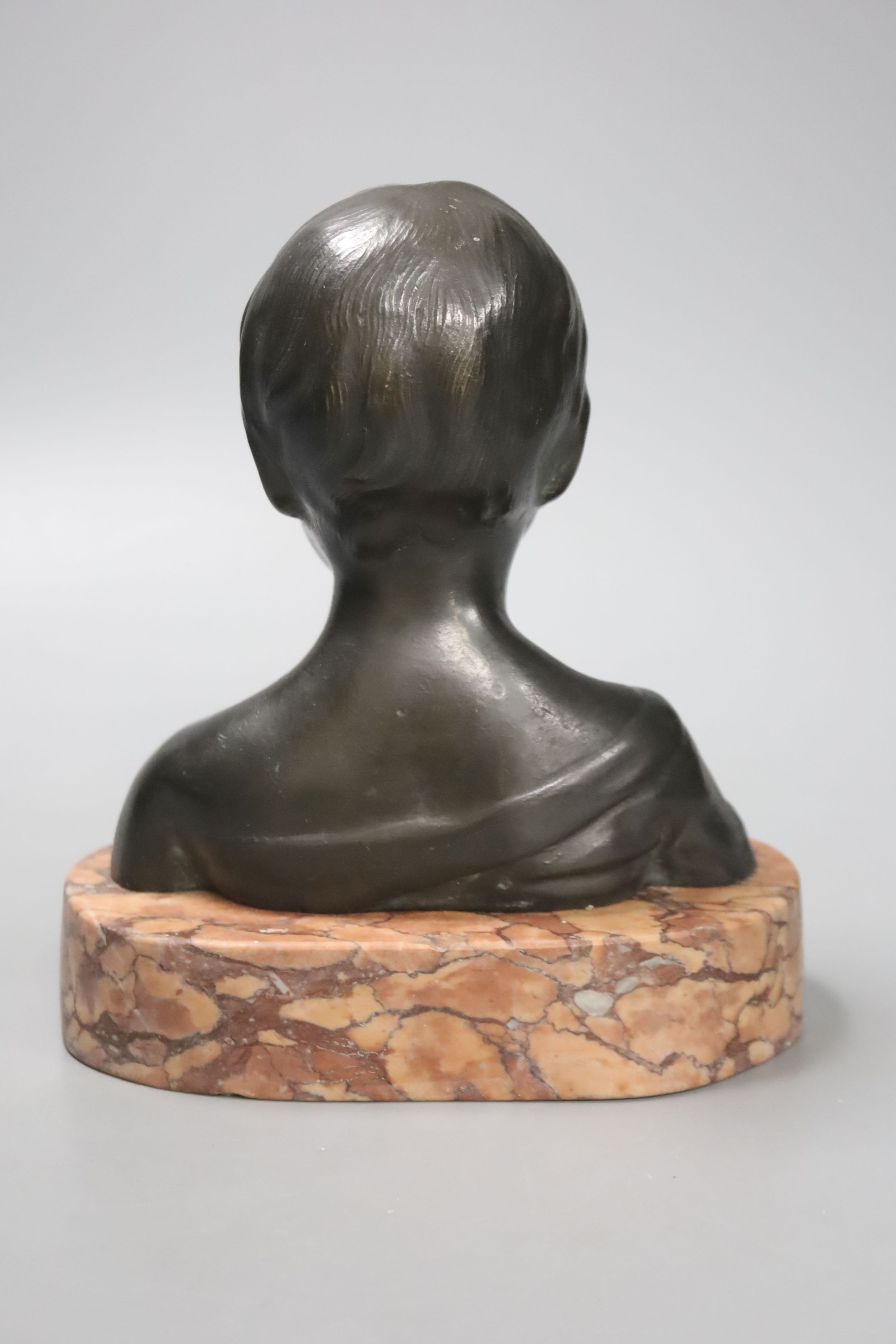 An early 20th century Continental bronze bust of a young girl, on a polished red marble base, 17cm high